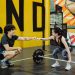 Man and woman in gym sharing a fist bump to celebrate a workout session.